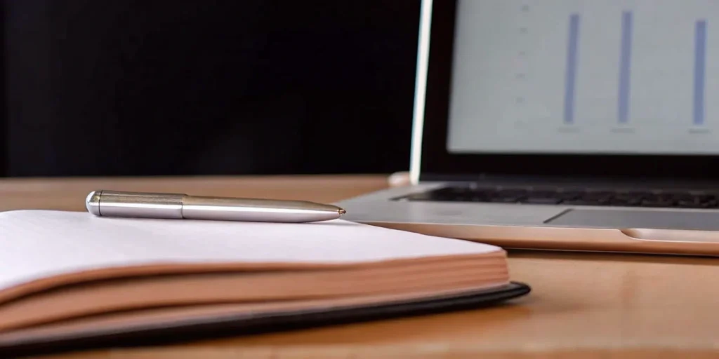 FDA audit preparation services: Notebook, pen, and laptop with charts.