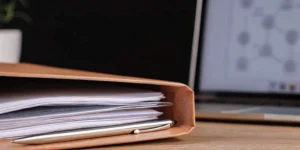 PMTA application documents, pen, and laptop.
