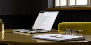 PMTA expert consultant workspace with laptop, notebook, and pen.
