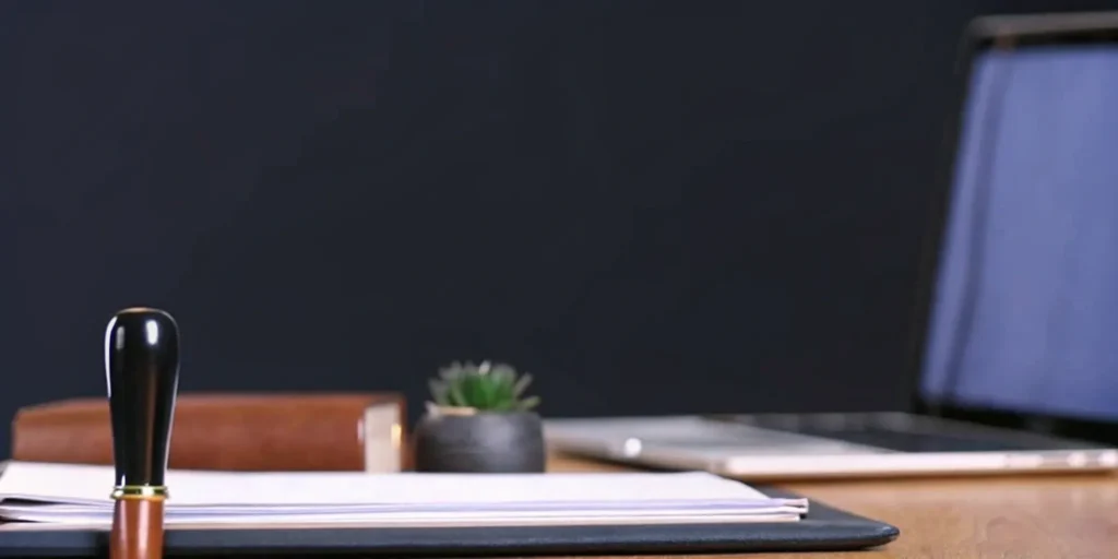 Compliance audit tools for consulting: Laptop, documents, and stamp.