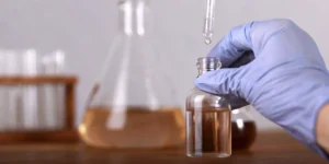 Scientist conducting extractables and leachables testing with a pipette in a laboratory.