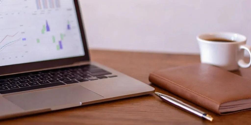 Analyzing data charts for a pharmaceutical regulatory consulting strategy on a laptop.