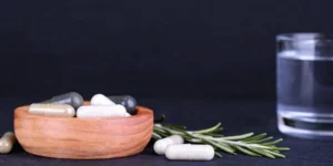 Different types of PMA supplement capsules in a wooden bowl.