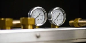 Pressure gauges and fittings symbolizing control measures for a compliant risk management file (RMF).