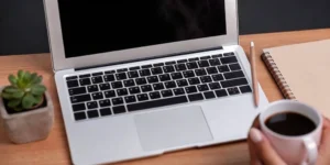 Laptop and notebook on a desk for preparing a medical device 510(k) summary.