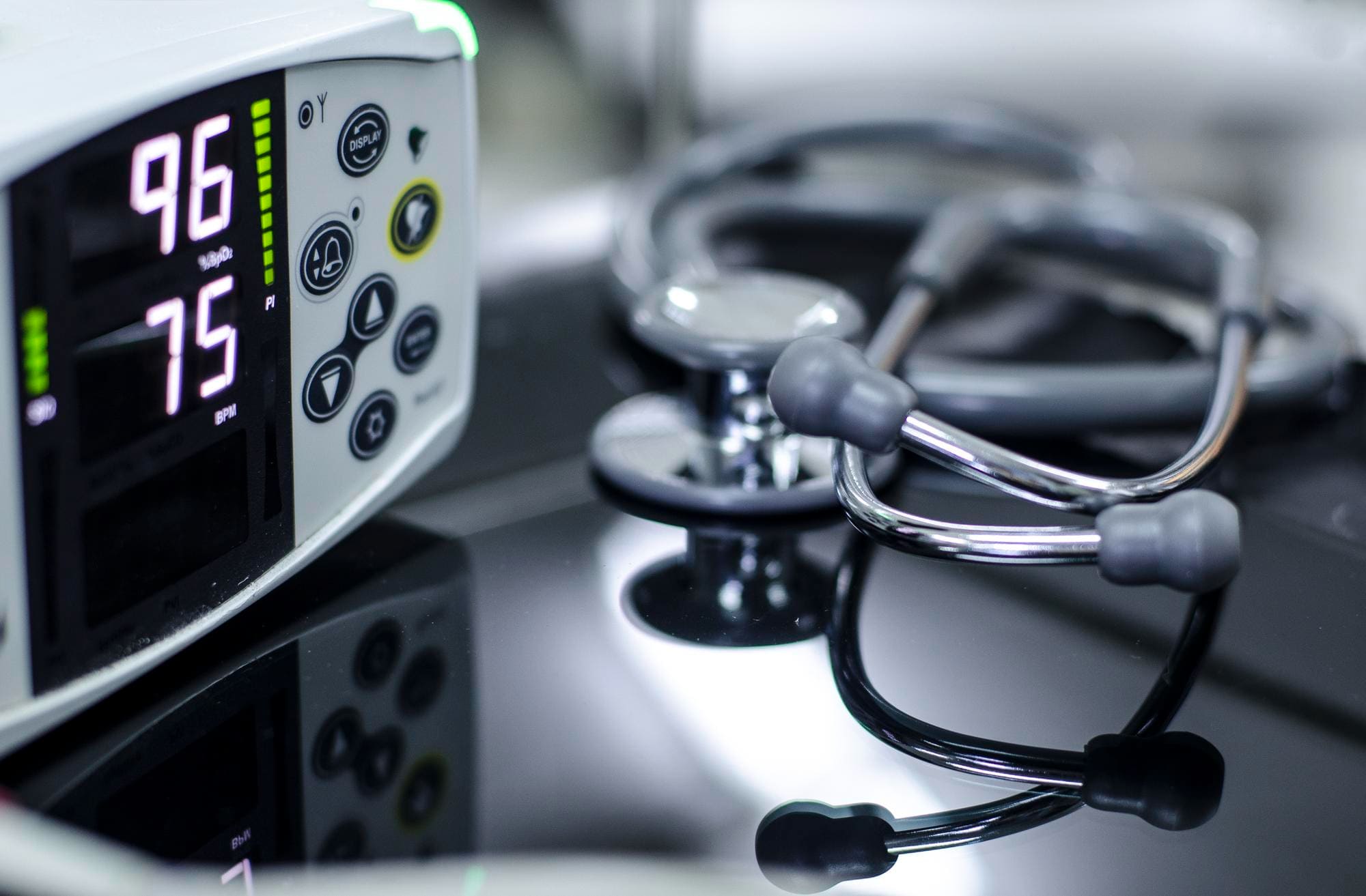 Close-up of a vital signs monitor and a stethoscope.