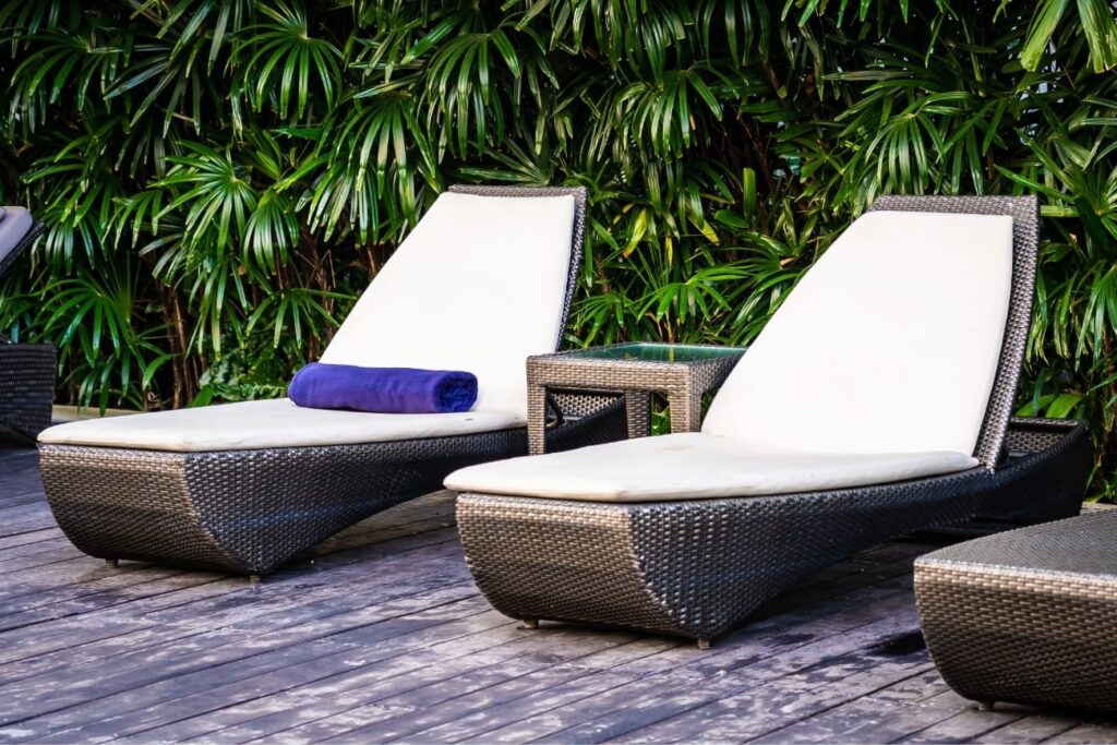 Two wicker lounge chairs with purple towel