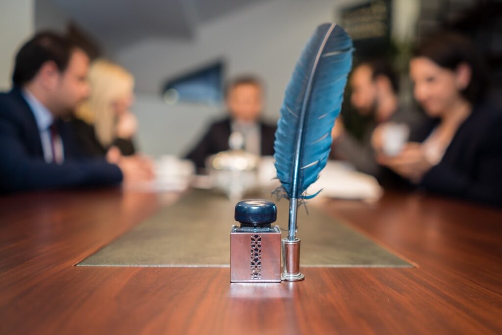 Blue quill and inkwell on meeting table