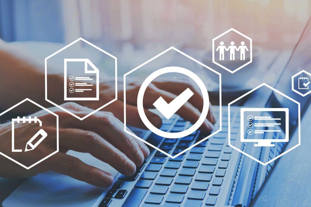 Hands typing on laptop with digital approval icons
