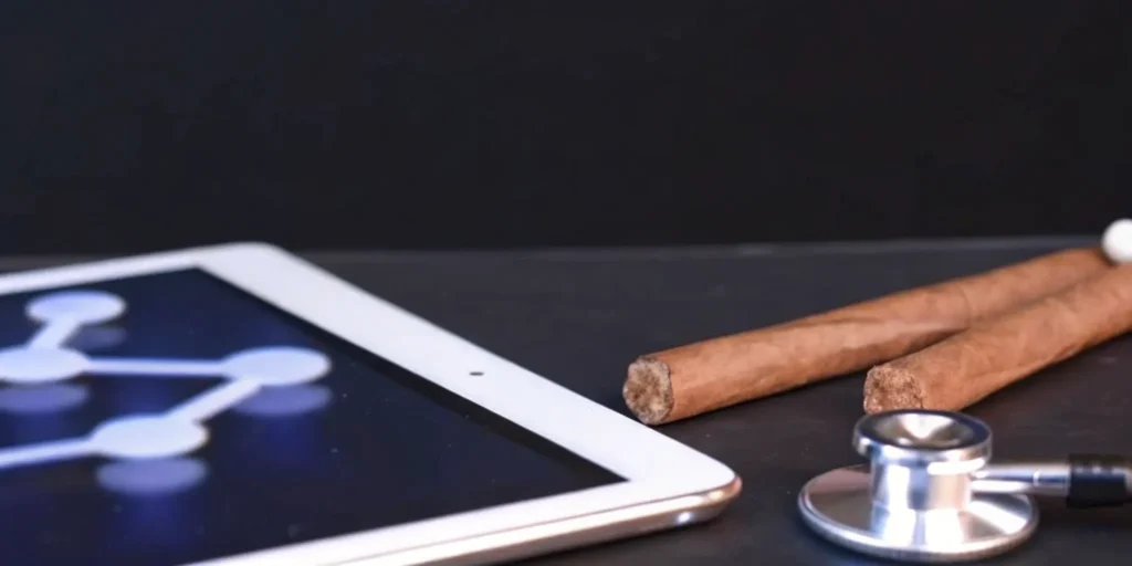 Tablet, stethoscope, and cigars on desk