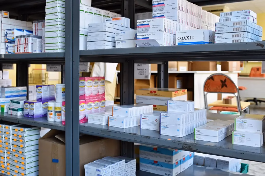 Metal shelves stocked with various boxes of medication.
